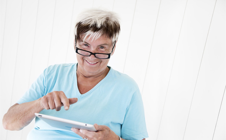 En äldre kvinna har ett digitalt samtal på sin dator.